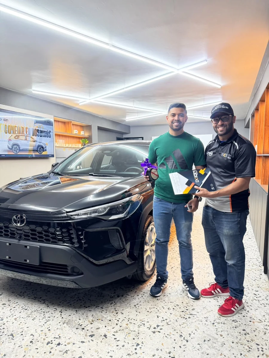 Cliente y asesor de EXION junto a un Toyota Corolla Cross negro durante su entrega