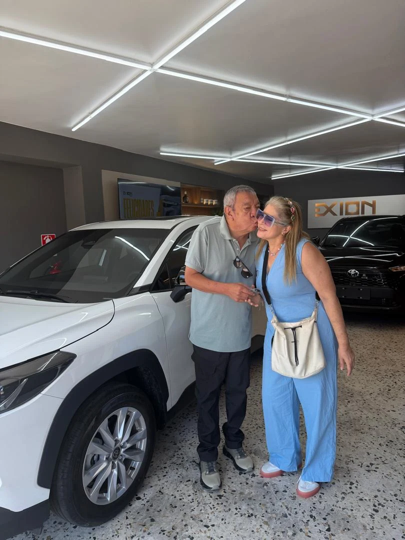 Familia celebrando la entrega de un Toyota Corolla Cross blanco